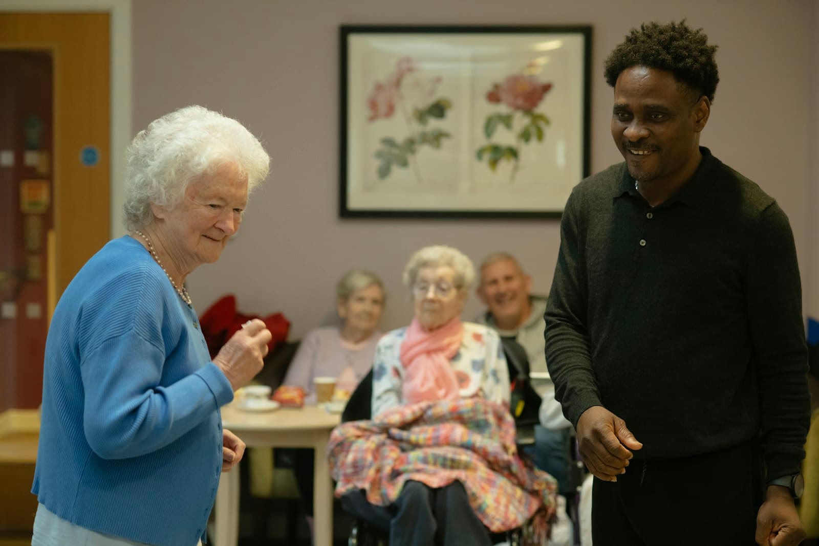 A caregiver and resident sharing a warm moment in a community common room