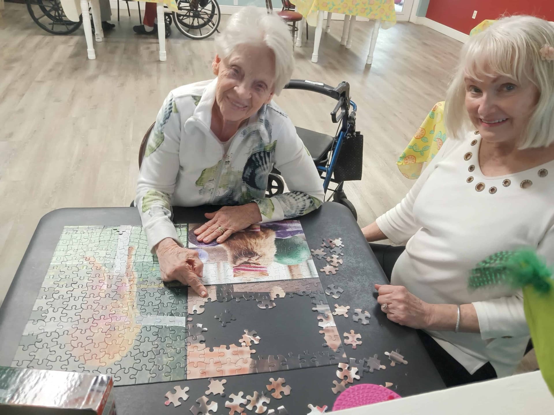 Two residents working a puzzle together at Sugarmill Manor